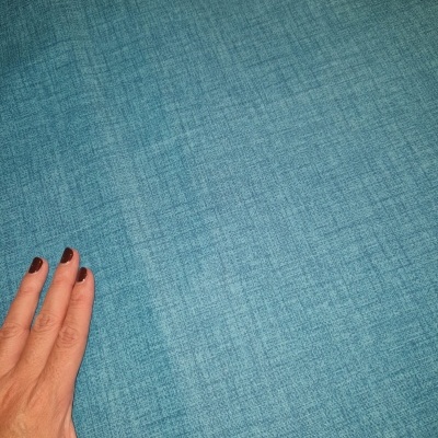 Mão sobre tecido azul texturizado