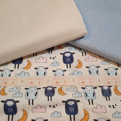 tecidos com padrão de ovelhas e lisos em bege e azul claro