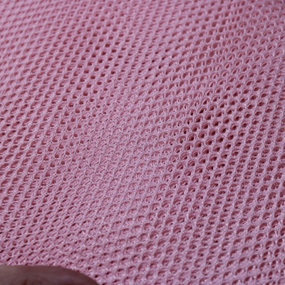 Tecido cor-de-rosa de malha com padrão de pequenos buracos