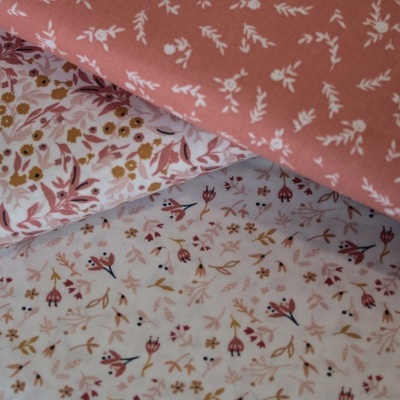 Três tecidos com padrões florais em diferentes cores e texturas suaves