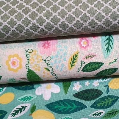 Três tecidos com padrões florais e geométricos em cinza, bege e verde