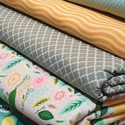 Tecidos dobrados com padrões geométricos, ondulados e florais coloridos