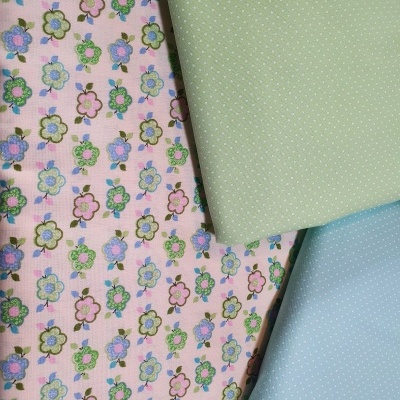 Três tecidos com padrão floral em rosa e com pontos em verde e azul