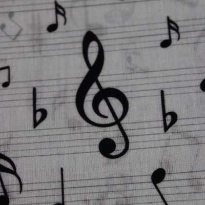 Tecido branco com notas musicais e claves pretas estampadas