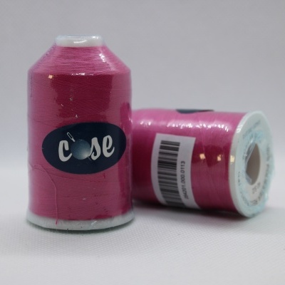 Bobinas de linha de costura rosa com rótulo azul e código de barras sobre fundo branco