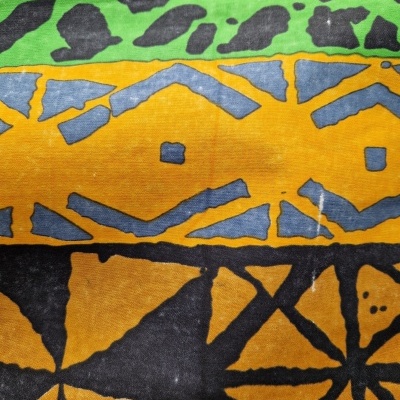 tecido com padrão geométrico e cores verde, amarelo, preto e cinzento