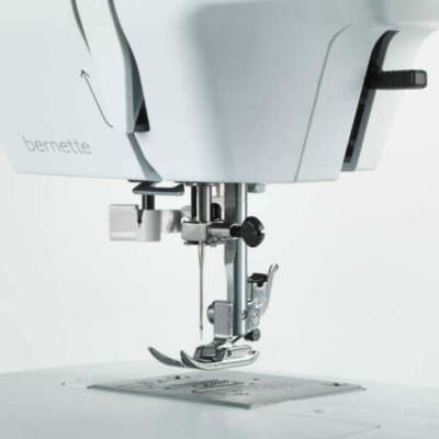 máquina de costura branca bernette com agulha e pedal