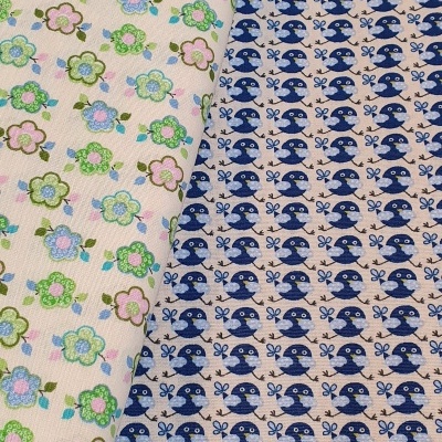 Tecidos com padrões de flores coloridas e pássaros azuis