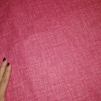 Tecido rosa texturizado com mão segurando a borda