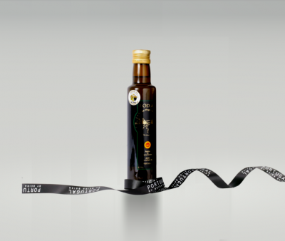 Garrafa de azeite castanho escuro com rótulo preto e dourado sobre fundo cinza claro