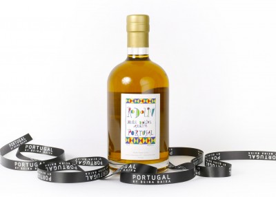 Garrafa de vidro ambar com etiqueta colorida e fita preta com texto Portugal