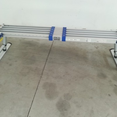 Bancada de trabalho metálica dobrável numa área com chão de cimento