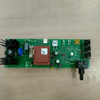 Placa eletrónica verde com componentes incluindo dissipadores, bloco vermelho com etiqueta, resistores, condensadores e potenciômetro preto