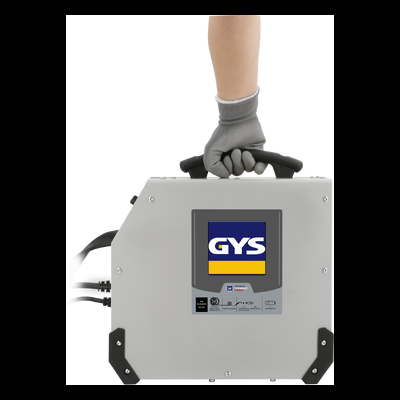 Máquina de soldar cinzenta com pega preta e etiqueta GYS, segurada por mão com luva cinzenta