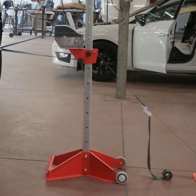 Suporte metálico ajustável com base vermelha em oficina mecânica