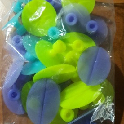 Pacote com ventosas de plástico verde e roxo sobre madeira