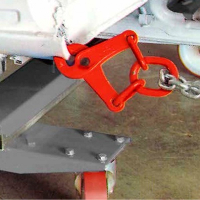 Gancho de engate vermelho ligado a corrente e estrutura metálica cinzenta com rodas.