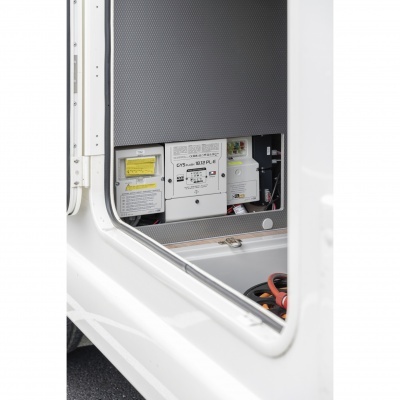 Painel interior de compartimento com componentes eléctricos e cabos num veículo branco