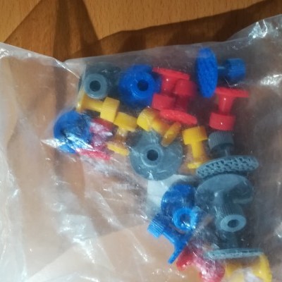 Pacote transparente com peças de construção coloridas em superfície de madeira