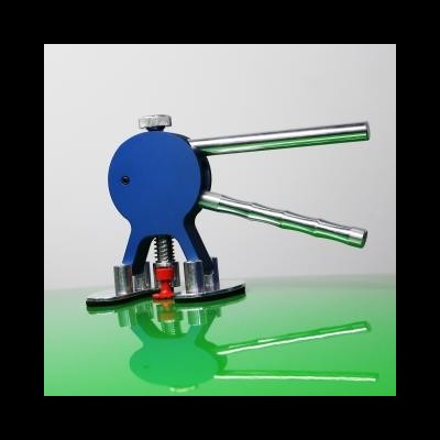 Prensa manual azul com alavancas metálicas sobre superfície verde