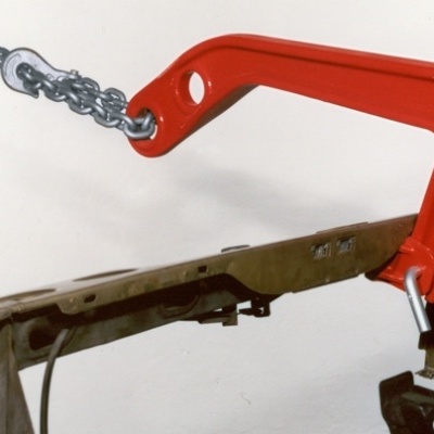 gancho levantador vermelho com corrente metálica numa estrutura verde militar