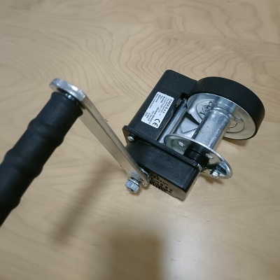 Manivela metálica com punho preto e roda em metal e borracha