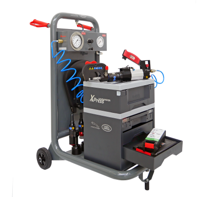 Equipamento industrial cinza com rodas, manómetros, mangueira azul e gaveta aberta com ferramentas.