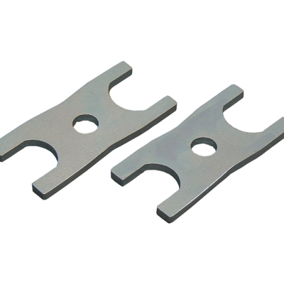 Duas peças metálicas planas cinzentas com recortes e orifício central