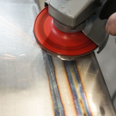 Lixadora elétrica com disco vermelho a polir chapa metálica