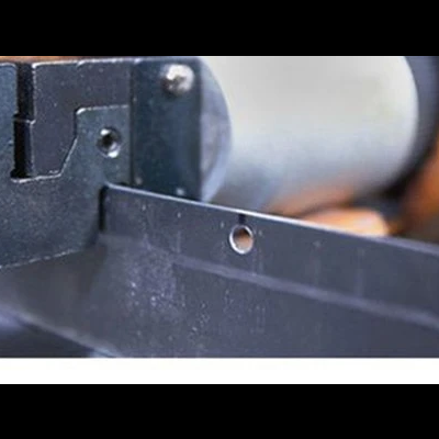 Lâmina metálica preta fixada a estrutura de plástico preto de equipamento mecânico