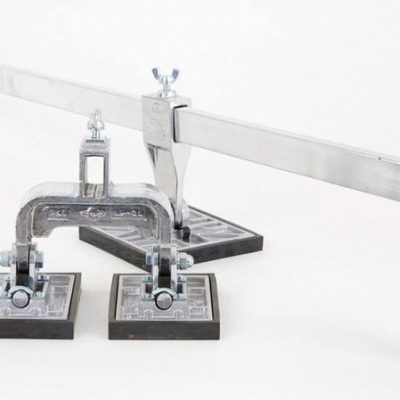 Suporte metálico com barra horizontal e três ventosas quadradas pretas sobre fundo branco