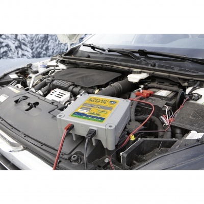 Carro com motor exposto e carregador de bateria conectado