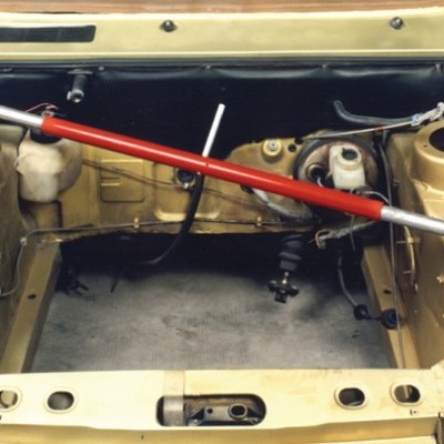 Compartimento do motor vazio de carro bege com barra de torção vermelha e cinzenta