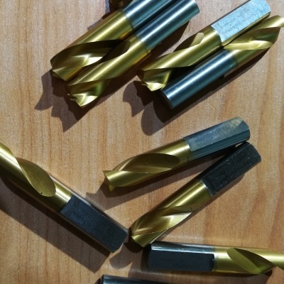 brocas metálicas helicoidais douradas e azuis sobre madeira