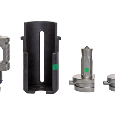 Conjunto de quatro peças metálicas industriais pequenas com marcas verdes