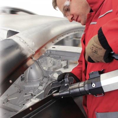 Pessoa a aplicar cola numa estrutura metálica com pistola de colar