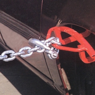 Gancho vermelho preso na parte traseira de carro preto com corrente prateada segurando o veículo