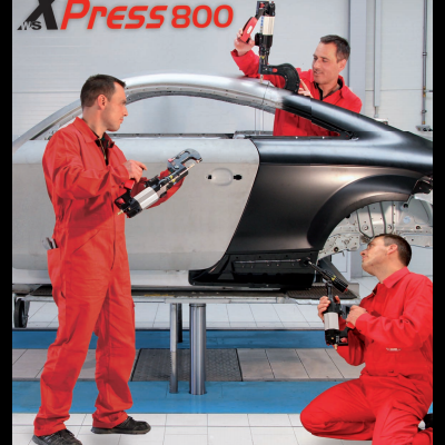 Homens com ferramentas junto a carroçaria em oficina com inscrição Xpress 800