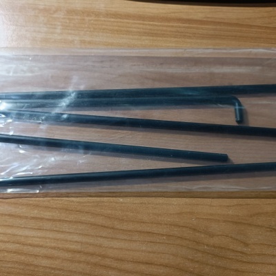 Varas metálicas pretas finas em embalagem plástica transparentes sobre madeira clara
