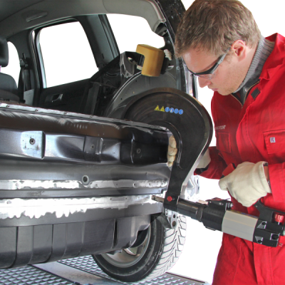 Profissional a reparar carro preto na parte lateral usando ferramenta elétrica