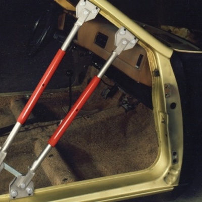 Estrutura metálica vermelha e cinza no interior de carroçaria amarela sem portas