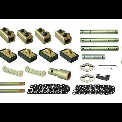 Vários componentes metálicos dourados e ferramentas organizados sobre fundo branco com um pequeno suporte azul