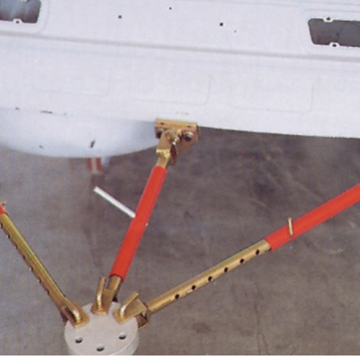 Detalhe de hastes metálicas vermelhas e douradas ligadas a estrutura branca