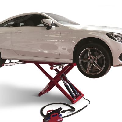 Carro branco de duas portas levantado por macaco hidráulico vermelho