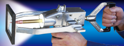 Ferramenta metálica com alça preta e peça vermelha segurada por mãos