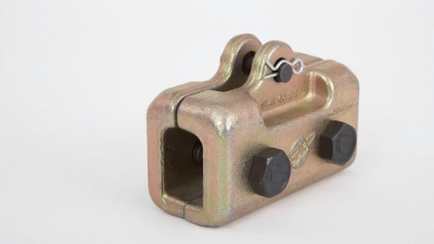 Peça metálica industrial dourada com parafusos pretos e pino de segurança