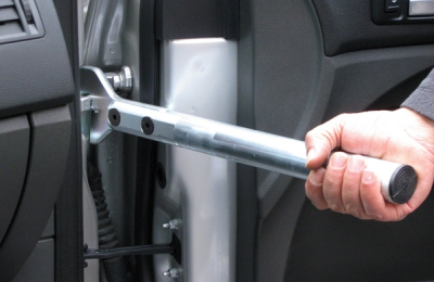 Ferramenta metálica cilíndrica prateada segurada dentro de carro