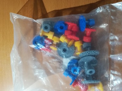 Pacote transparente com peças de construção coloridas em superfície de madeira