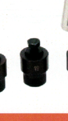 Três soquetes metálicos pretos sobre superfície branca, centro com marcação 19