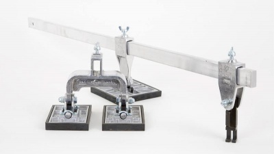 Suporte metálico com barra horizontal e três ventosas quadradas pretas sobre fundo branco